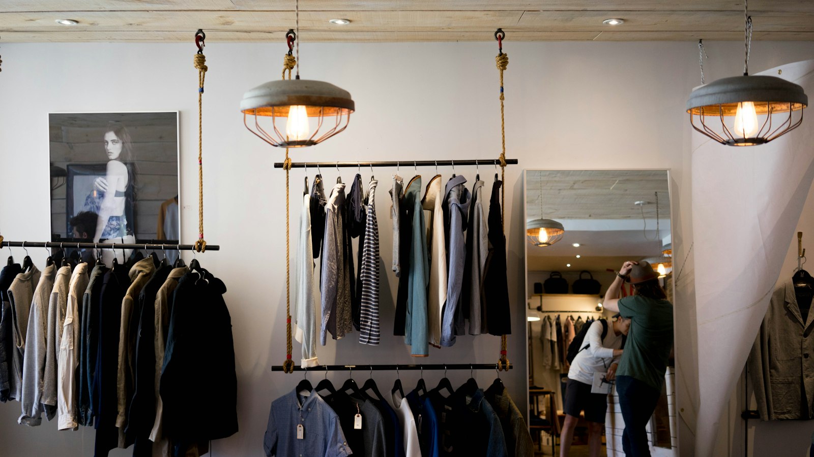 Garment rail in a moody boutique interior — the Galliano x Zara collection brings couture technique to the high-street rack