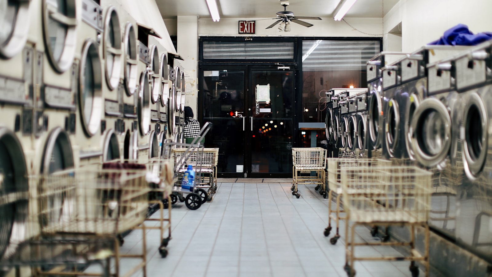 Moody empty laundromat with washing machines — how to wash graphic tees without ruining the print