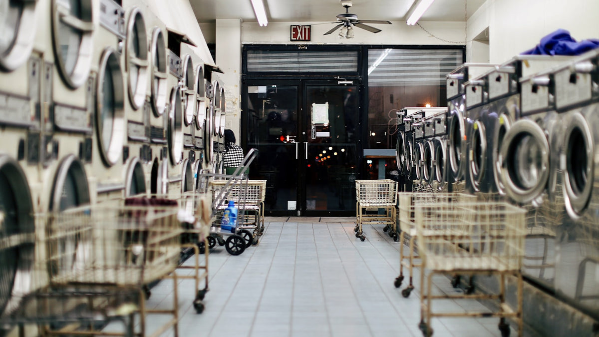 Moody empty laundromat with washing machines — how to wash graphic tees without ruining the print