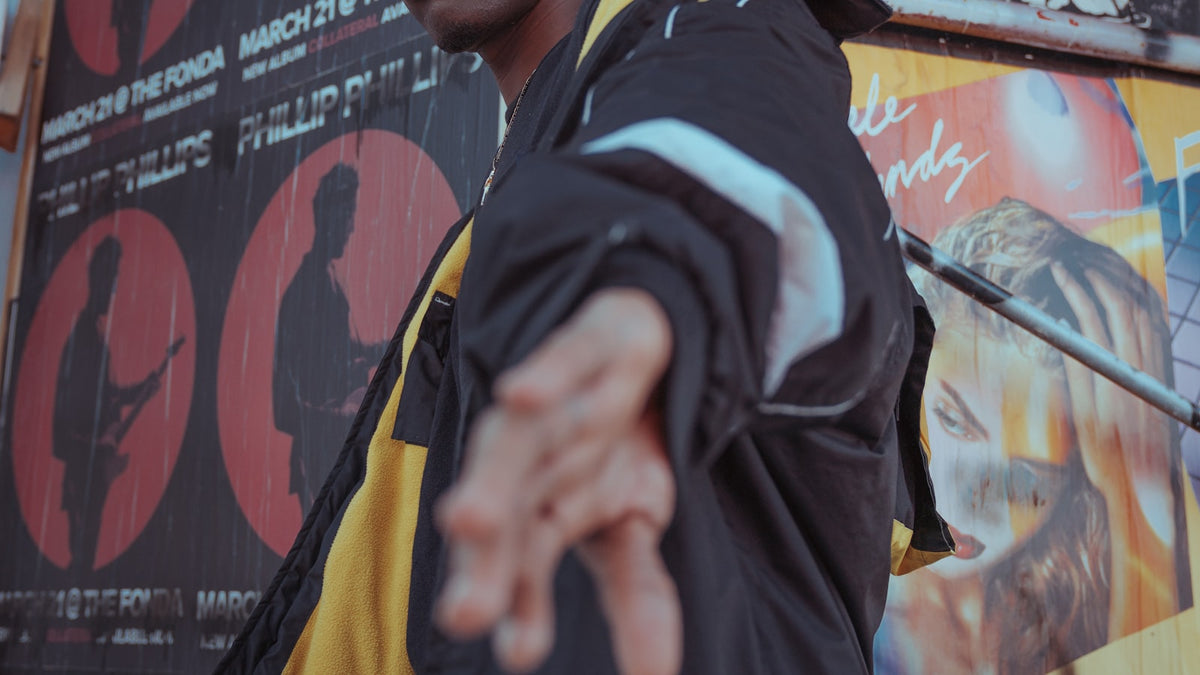 Independent streetwear brands: moody editorial portrait of a man in a jacket against a concrete wall
