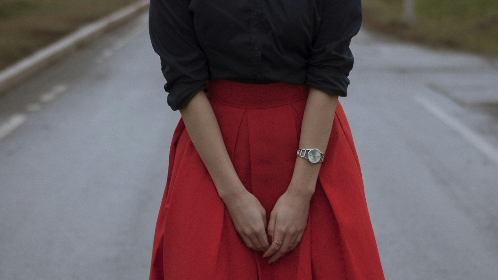 Moody editorial street photo of a red skirt outfit — the Prada skirts show energy, translated to the sidewalk