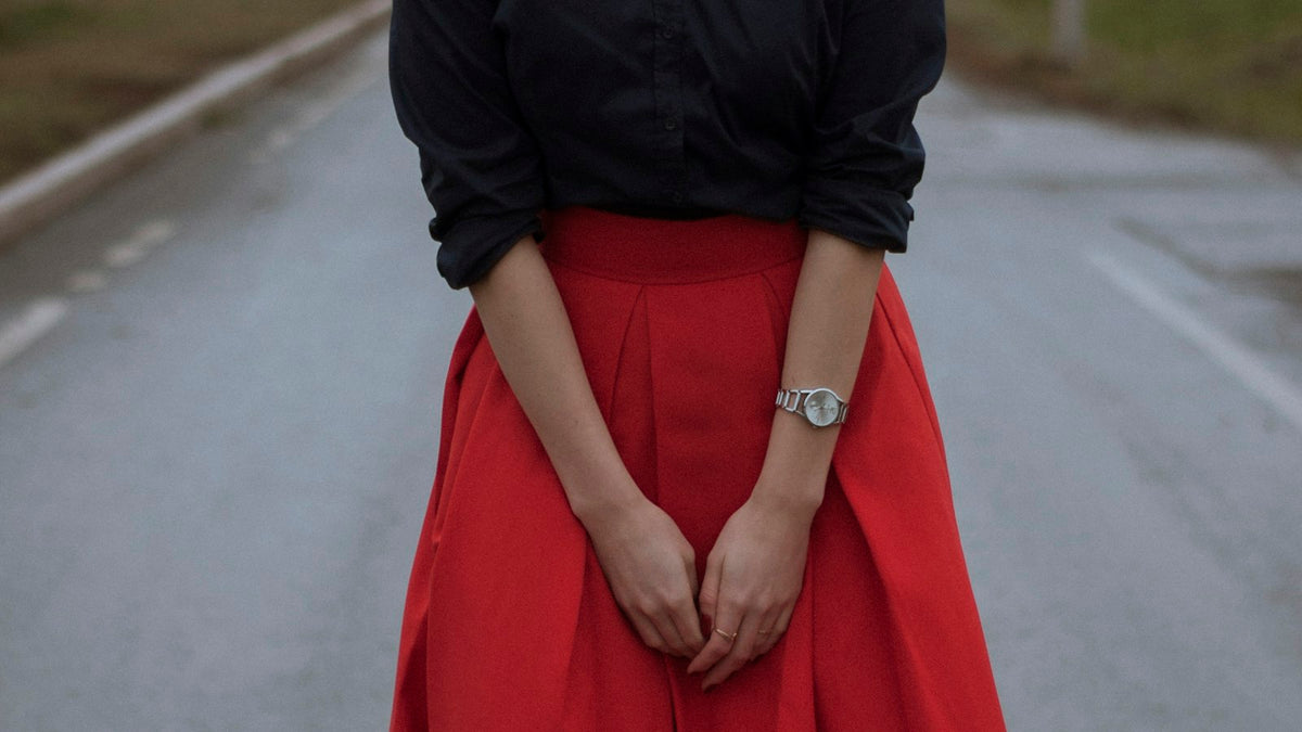 Moody editorial street photo of a red skirt outfit — the Prada skirts show energy, translated to the sidewalk