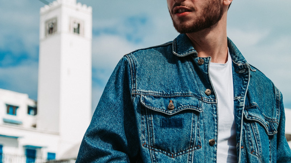 Man in a washed denim jacket on a city street — how to style a denim jacket for streetwear