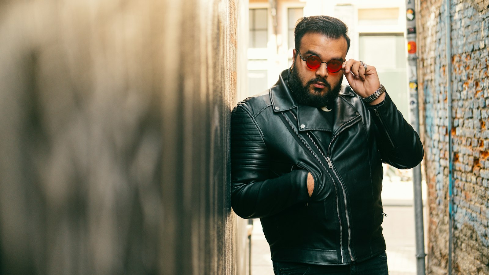 Man in a black leather jacket and sunglasses — how to style a leather jacket for streetwear