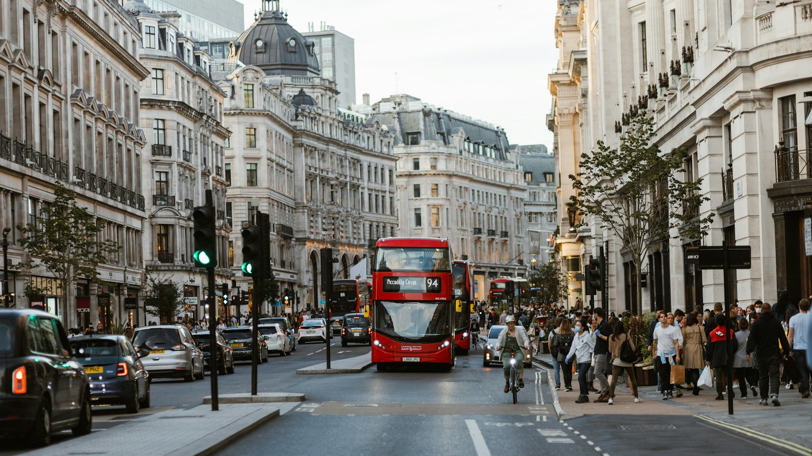 Street style crowd and a red bus on a busy London street as London Fashion Week 2026 opens