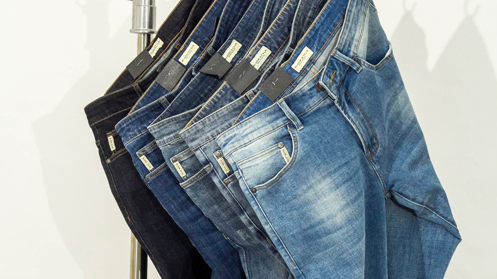 How should jeans fit — denim hanging on a minimal clothes rack, streetwear fit guide