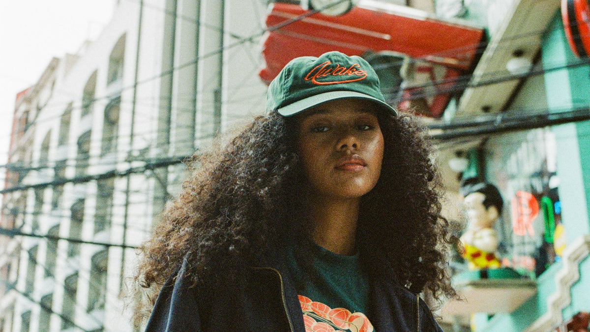Street style energy ahead of ComplexCon 2026: a skater holding a deck overhead on a city street