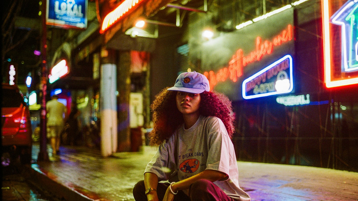 Skater sitting on a skateboard in a city street — streetwear collabs and skate culture