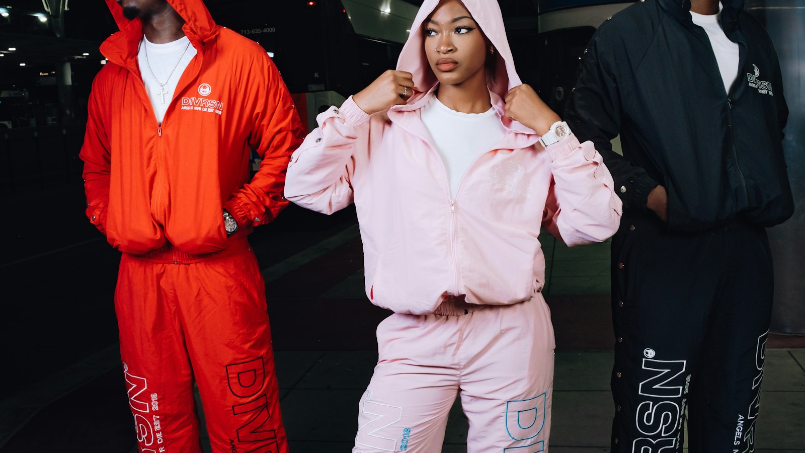 Three people in matching tracksuits on a city street at night — how to style a tracksuit