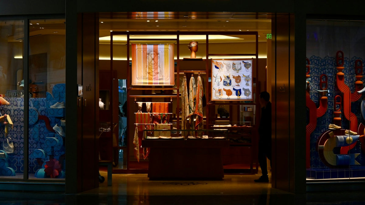 Luxury fashion store window glowing at night, the retail theater energy of Gucci SS27